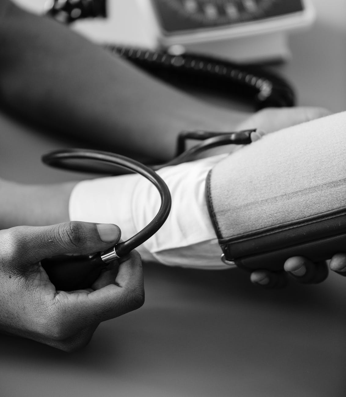 greyscale photo of person taking blood pressure